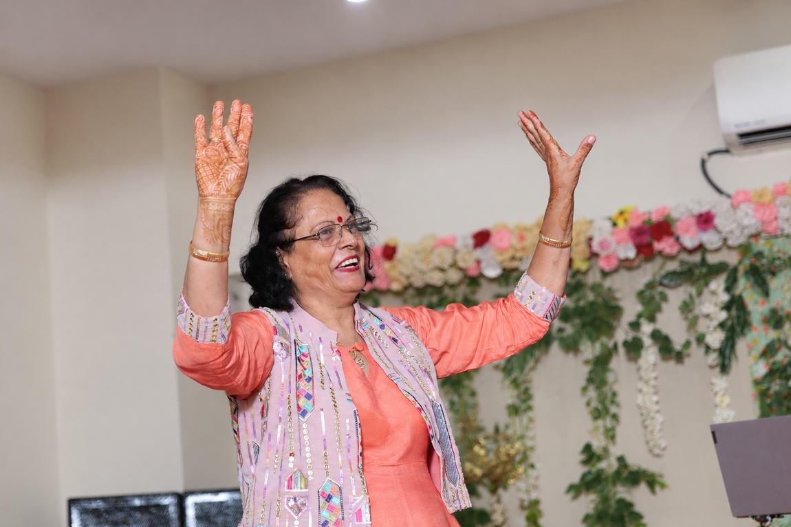 On stage, celebrating with joy and mehndi-adorned hands